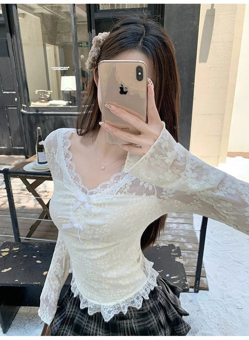 Person wearing a white lace top and plaid skirt outdoors.